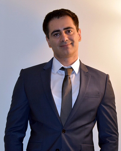Headshot of Alireza Khaligh, a man smiling wearing a suit