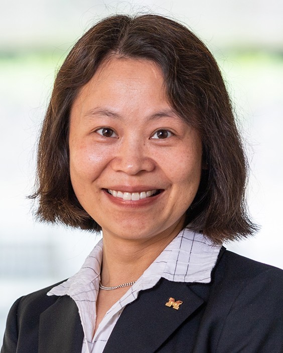 Headshot of Mingyan Liu, a woman smiling wearing a dark suit and light shirt